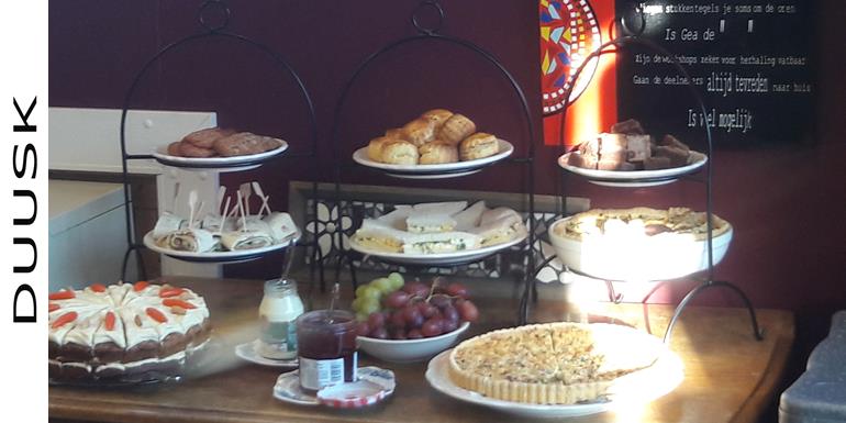 Een High TEaop een eiken tafel met daarop 9 schalen met hapjes, taart druiven megebracht voor het vrijgezellenfeest een heerlijk.