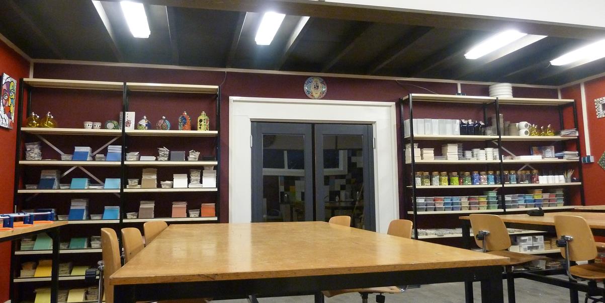 Cursus en teambuilding atelier, antraciet plafond, openslaande deuren grote Cursus tafels, rode wanden.